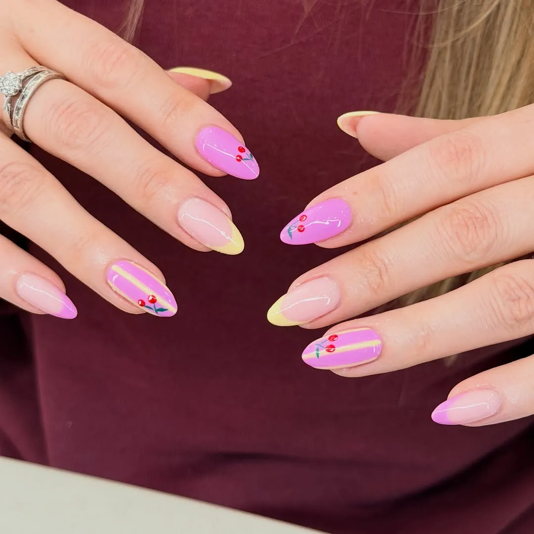 Almond nails in lilac and lemon french with hand-painted cherry art, over a burgundy jumper — by Nails First Garston
