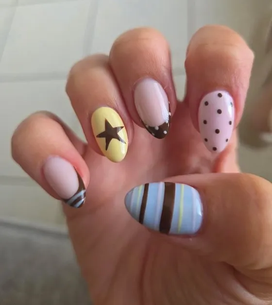 Playful BIAB nail art — yellow star, polka dots and stripes on almond nails, by Nails First Garston