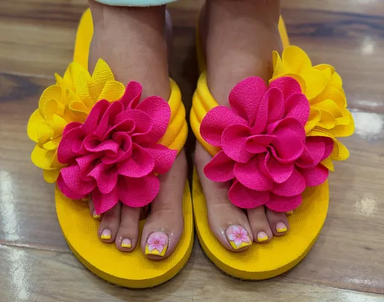 Summer pedicure — bright painted toes in yellow flower flip-flops, by Nails First Garston